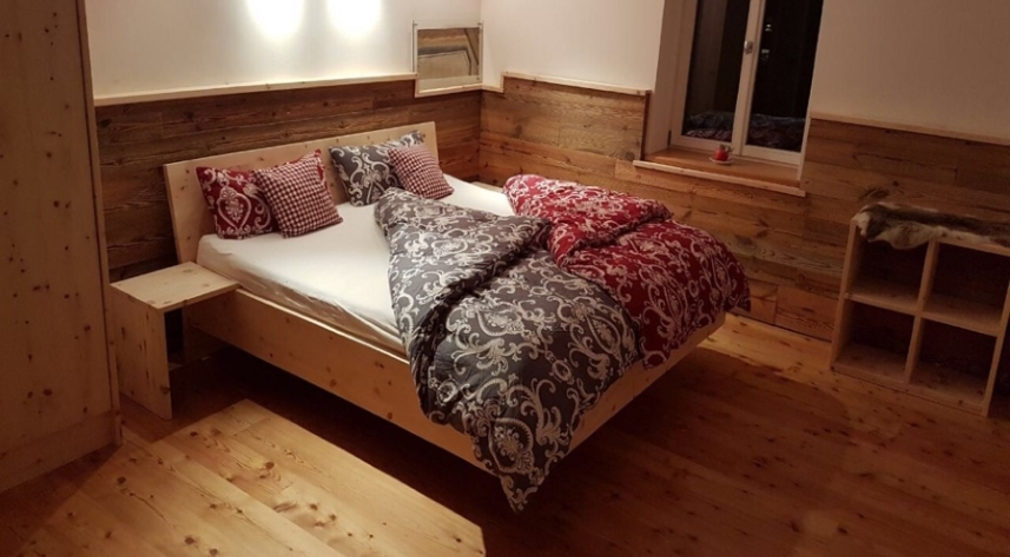 Zirbenschlafzimmer mit Altholzwandverkleidung